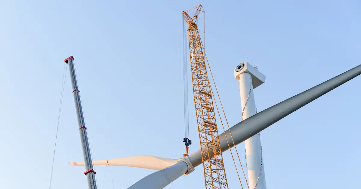 Kran hebt Rotor einer Windenergieanlage